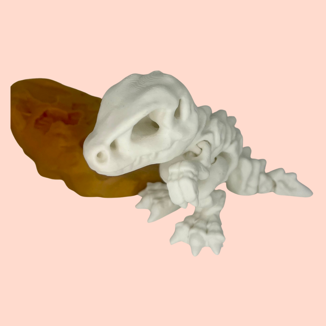 White ceramic lizard figurine on a pink background