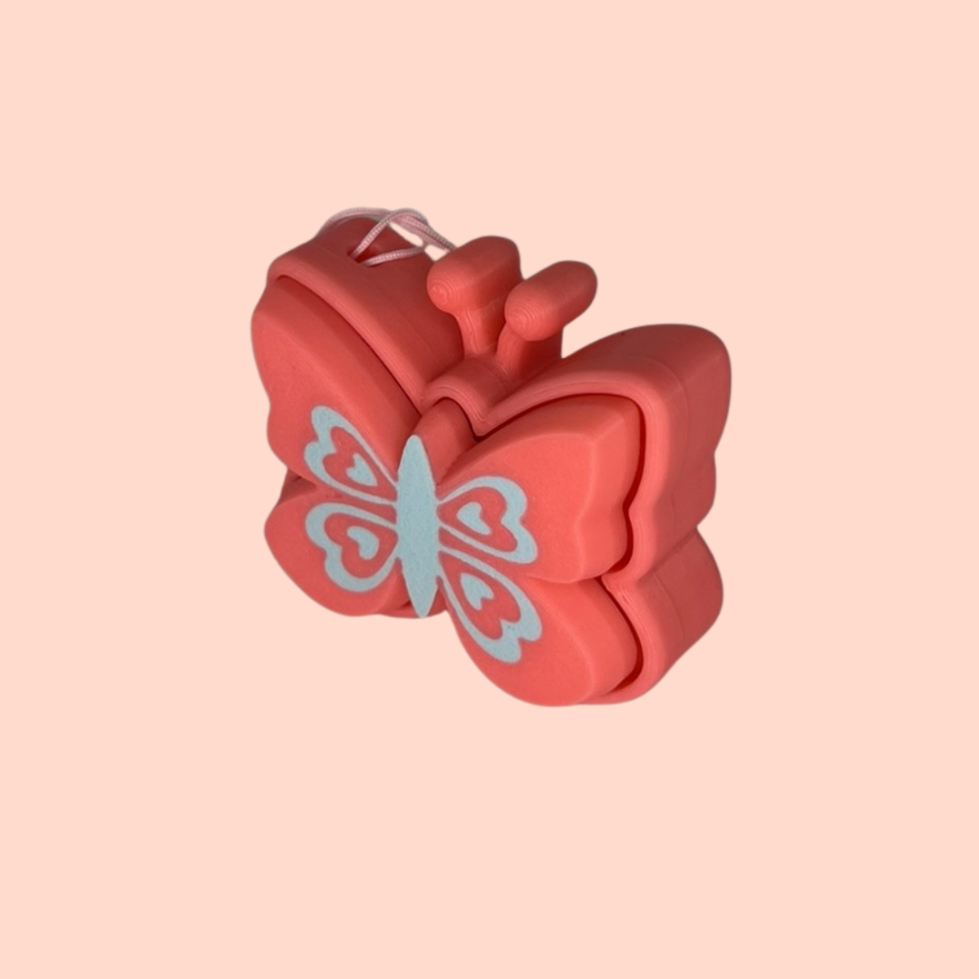 Red butterfly-shaped hair clip on a pink background