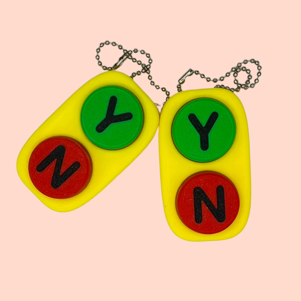 Two colorful keychains with letters 'NY' on a pink background