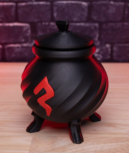 Black and red decorative pot with a symbol on a wooden surface and brick wall background