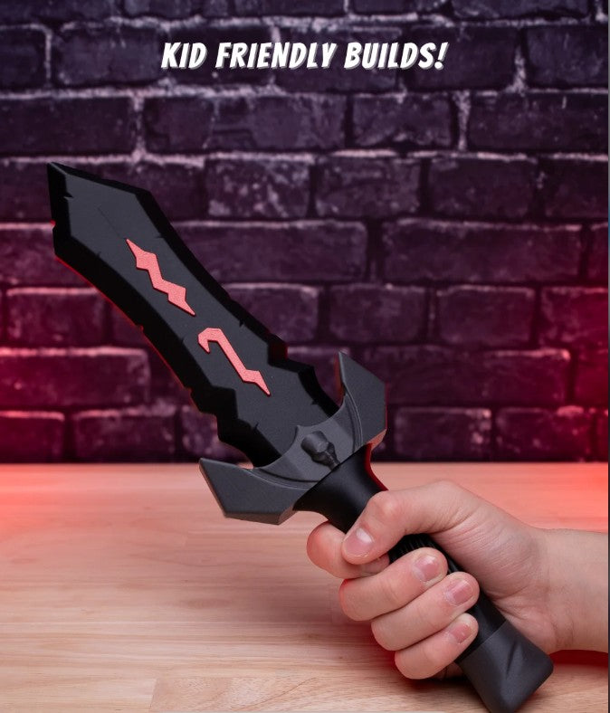 Black toy sword with red accents held by a hand against a brick wall background.
