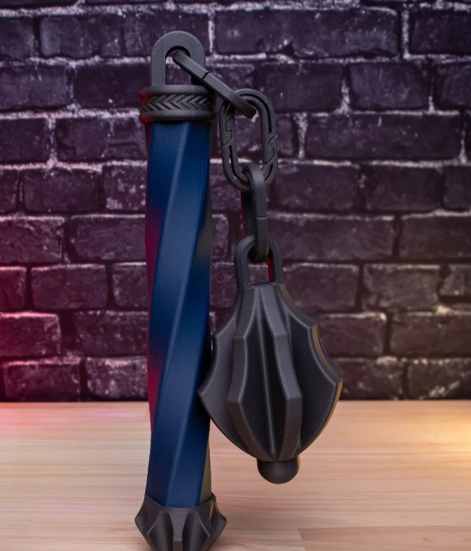 Black and blue tool with a spherical component on a wooden surface against a brick wall background