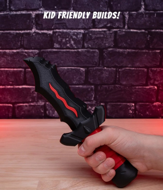 Hand holding a black and red tool against a brick wall with 'KID FRIENDLY BUILDS!' text.