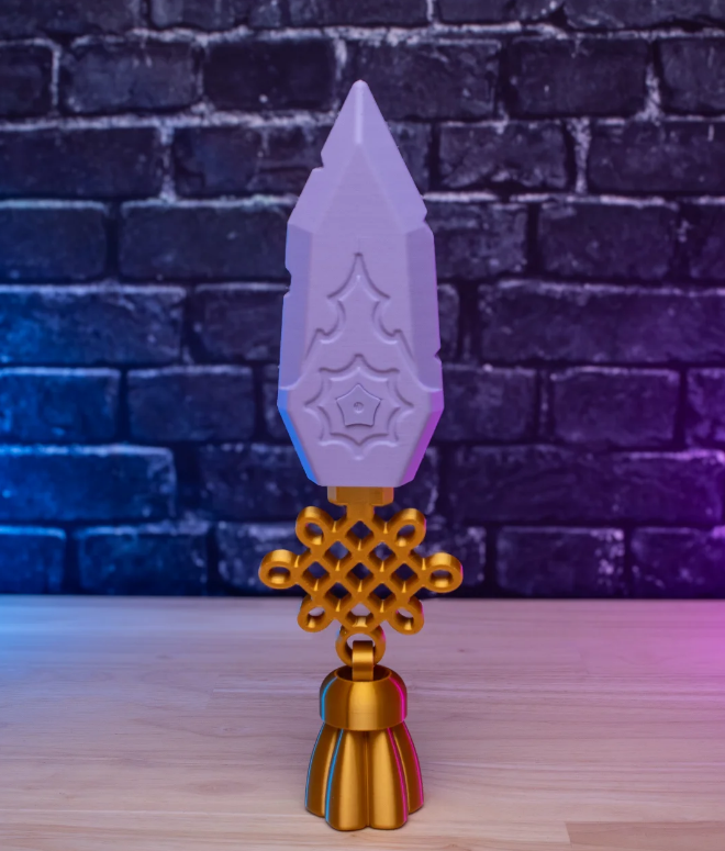 Decorative object with a purple top and gold base on a wooden surface with a brick wall background