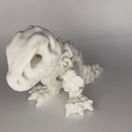 hand playing with white dinosaur articulated figure moving side to side